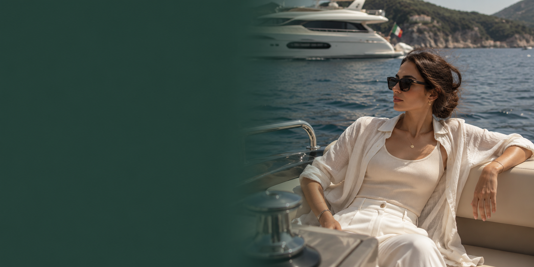 A woman wearing a white linen shirt and matching trousers sits on a yacht deck, wearing dark sunglasses, with a blue sea and another yacht in the background.